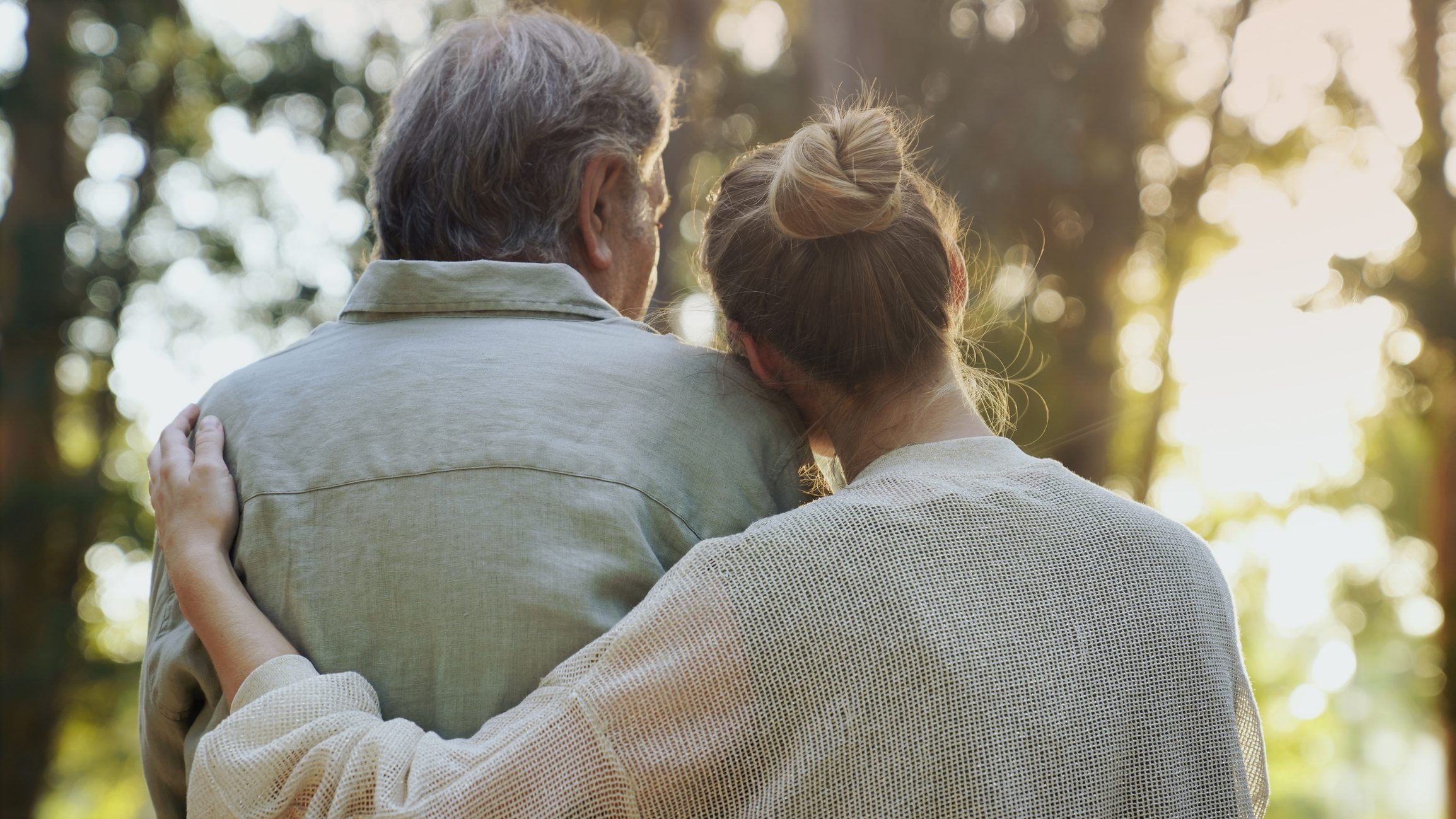 Couple hugging in a sunlit forest