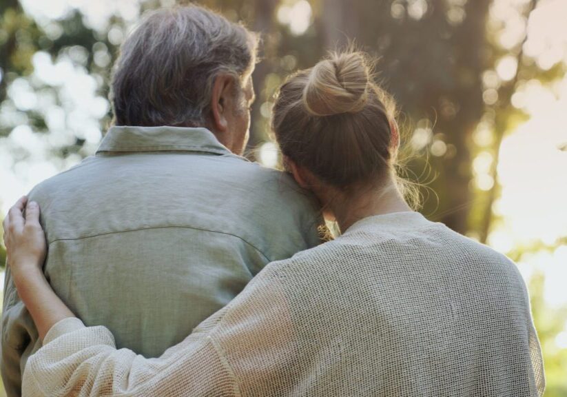 Couple hugging in a sunlit forest